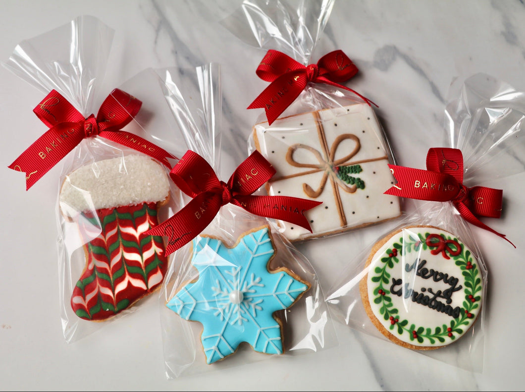 Decorative cookies in clear packaging with red ribbons on a light background